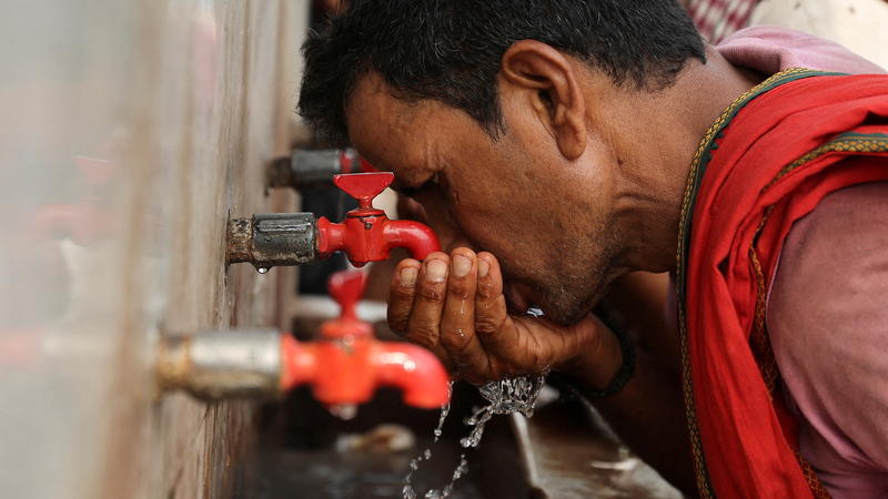FILE PHOTO: A labourer drinks water from a public drinking water tap on a hot summer day in the old quarters of Delhi, India, May 4, 2022. REUTERS/Anushree Fadnavis/File Photo