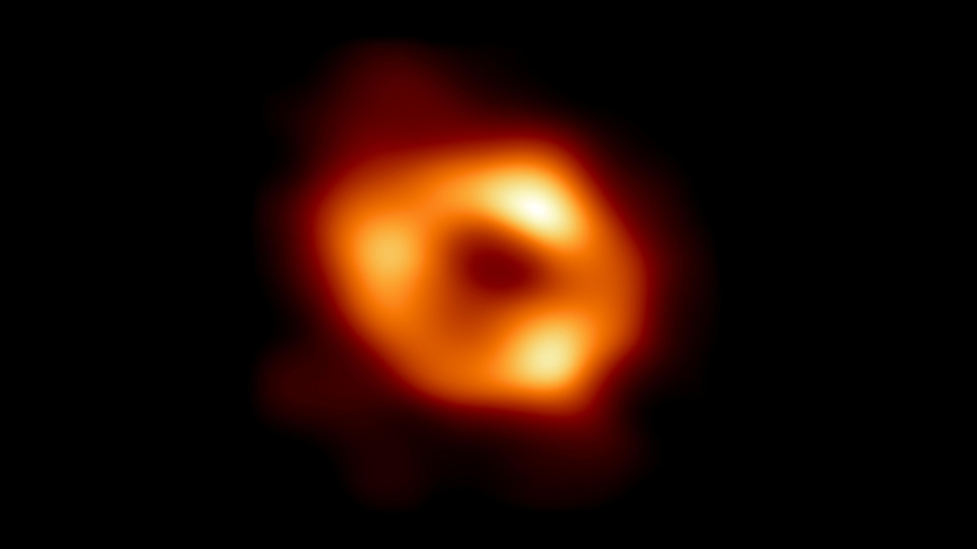 This is the first image of Sagittarius A* (or Sgr A* for short), the supermassive black hole at the center of our galaxy. It was captured by the Event Horizon Telescope (EHT), an array which linked together radio observatories across the planet to fo