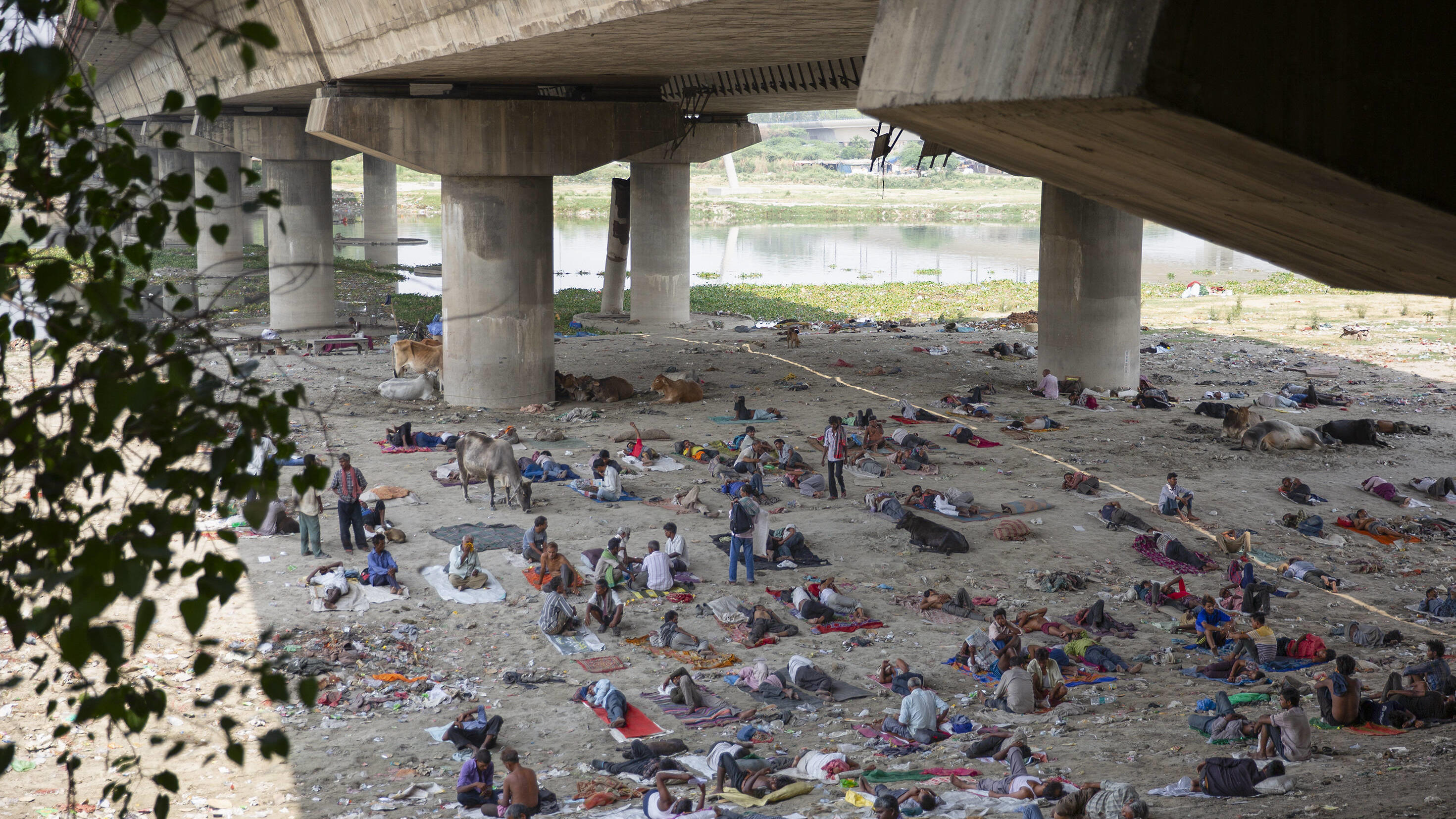 Indien, Menschen suchen unter einer Brücke Schutz vor der Hitze in Neu-Delhi 220512 -- NEW DELHI, May 12, 2022 -- People take rest under a bridge to get respite from the hot summer day in New Delhi,