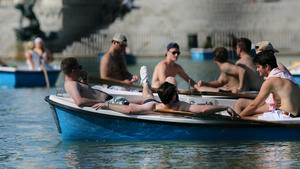 17.05.2022, Spanien, Madrid: Touristen fahren mit freiem Oberkörper auf einem Boot im Retiro-Park von Madrid. In Spanien herrschen für diese Jahreszeit ungewöhnlich hohe Temperaturen, die in einigen Gebieten 40 Grad Celsius erreichen. Nach Angaben des Wetterdienstes Aemet könnte dies die früheste Hitzewelle in Spanien seit Beginn der Aufzeichnungen werden. Foto: Cézaro De Luca/EUROPA PRESS/dpa +++ dpa-Bildfunk +++