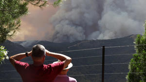 Anwohner des Dorfes Pujerra beobachten aus der Ferne die Löscharbeiten der Weltbrände der Region.