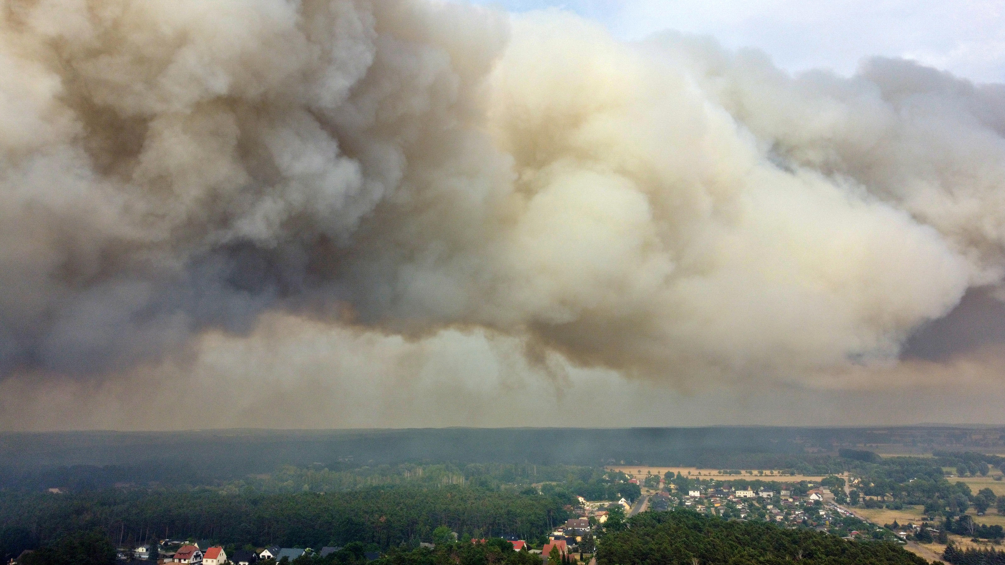 Eine große Rauchwolke steigt wegen eines Waldbrandes auf (Aufnahme mit Drohne). Das Feuer sei außer Kontrolle, womöglich drohe eine Evakuierung von Beelitz, sagte der Bürgermeister.