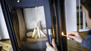 Symbolfoto: Eine Frau zuendet mit einem Streichholz einen Kaminofen an. Berlin, 21.02.2020 Berlin Deutschland *** Symbol photo A woman ends a stove with a match Berlin, 21 02 2020 Berlin Germany PUBLICATIONxINxGERxSUIxAUTxONLY Copyright: xThomasxTrutschel/photothek.dex 