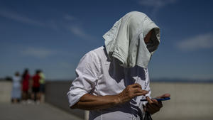 10.06.2022, Spanien, Madrid: Ein Mann bedeckt seinen Kopf vor der Sonne an einem heißen Tag in Madrid. Die Temperaturen steigen, und es wird vorhergesagt, dass sie bis zum Wochenende in einigen Teilen Spaniens über 40 Grad Celsius erreichen werden. Foto: Manu Fernandez/AP/dpa +++ dpa-Bildfunk +++
