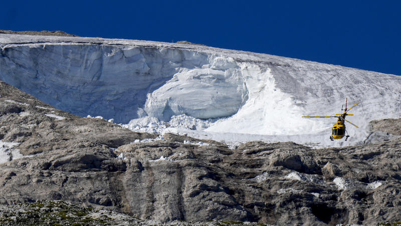 06.07.2022, Italien, Canazei: Ein Rettungshubschrauber fliegt über den Punta-Rocca-Gletscher in den italienischen Alpen. Nach dem massiven Gletscherbruch und einer Lawine geht in den Dolomiten die Suche nach weiteren Toten unter erschwerten Bedingung
