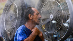 19.07.2022, Irak, Bagdad: Ein Mann kühlt sich vor einem Ventilator ab, während im Irak eine Hitzewelle herrscht. Der Irak erlebt Temperaturen von über 45 Grad Celsius. Foto: Ameer Al-Mohammedawi/dpa +++ dpa-Bildfunk +++