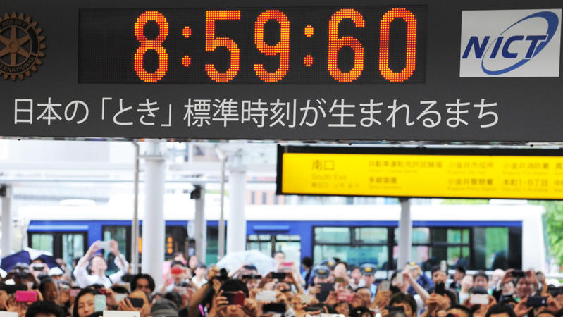Menschen in Japan fotografieren eine Uhr, die eine Schaltsekunde anzeigt, am 1. Juli 2015