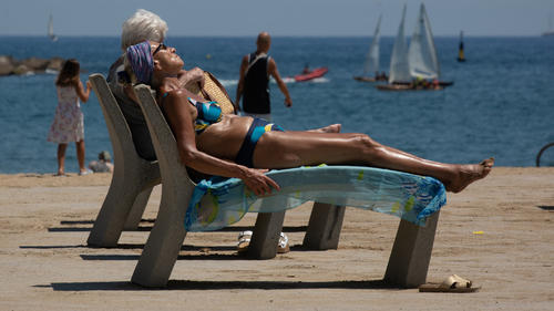 13.07.2022, Spanien, Barcelona: Mehrere Personen sonnen sich am Strand von Barceloneta. Die Temperaturen in Spanien klettern angesichts der aktuellen Hitzewelle auf Spitzenwerte. Foto: David Zorrakino/EUROPA PRESS/dpa +++ dpa-Bildfunk +++