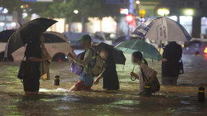 Menschen waten durch eine überschwemmte Straße im Süden Seouls in der Nacht am 8. August 2022 in Südkorea