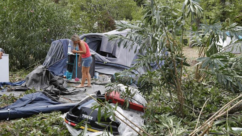 Frankreich, Coggia: Eine Frau packt die Reste der zerstörten Zelte und anderen Gegenstände auf dem Campingplatz Sagone ein, wo ein Baum während eines Sturms auf einen Bungalow stürzte und eine Person tötete. Bei heftigen Un