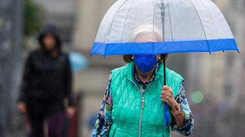 19.08.2022, Bayern, München: Eine Frau schützt sich bei Regen mit einem transparenten Schirm.  Auch für manche Regionen in Bayern sind weitere Regenfälle vorhergesagt. Foto: Peter Kneffel/dpa +++ dpa-Bildfunk +++