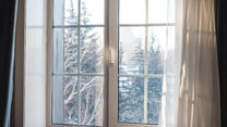 Fenster mit Ausblick auf weiße Winterlandschaft