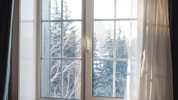 Fenster mit Ausblick auf weiße Winterlandschaft