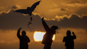 News Bilder des Tages Der Schattenriss von drei Personen zeichnet sich ab beim Drachensteigen vor Sonnenuntergang in Berlin, 07.11.2021. Berlin Deutschland *** The silhouette of three people stands out while flying a kite in front of sunset in Berlin, 07 11 2021 Berlin Germany Copyright: xFlorianxGaertner/photothek.dex