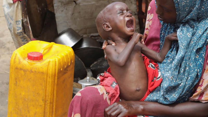 Amina Ali, a Somali woman affected by the worsening drought due to failed rain seasons, holds her child inside their makeshift shelter at the Alla Futo camp for internally displaced people in the outskirts of Mogadishu, Somalia September 23, 2022. RE
