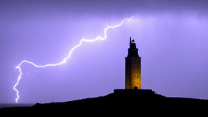 26.10.2022, Spanien, A Coruña: Ein Blitz erhellt den Nachthimmel neben dem Herkulesturm in A Coruña. Der Herkulesturm ist der älteste römische Leuchtturm der Welt und der einzige, der noch in Betrieb ist. Foto: M. Dylan/EUROPA PRESS/dpa +++ dpa-Bildfunk +++