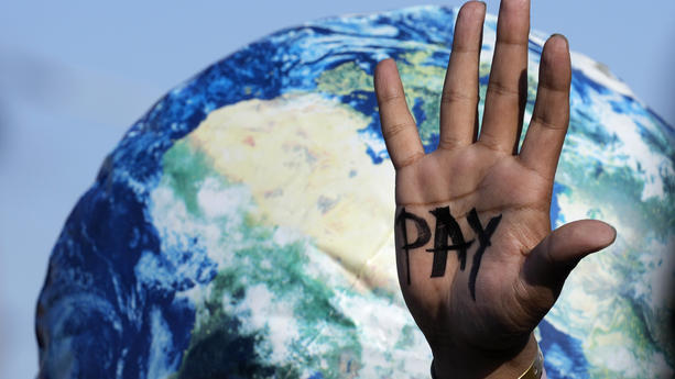 ARCHIV - 18.11.2022, Ägypten, Scharm el Scheich: Auf einer Hand ist "Pay" zu lesen, die auf dem UN-Klimagipfel COP27 bei einem Protest der Entschädigungen für Verluste und Schäden fordert. Foto: Peter Dejong/AP/dpa +++ dpa-Bildfunk +++