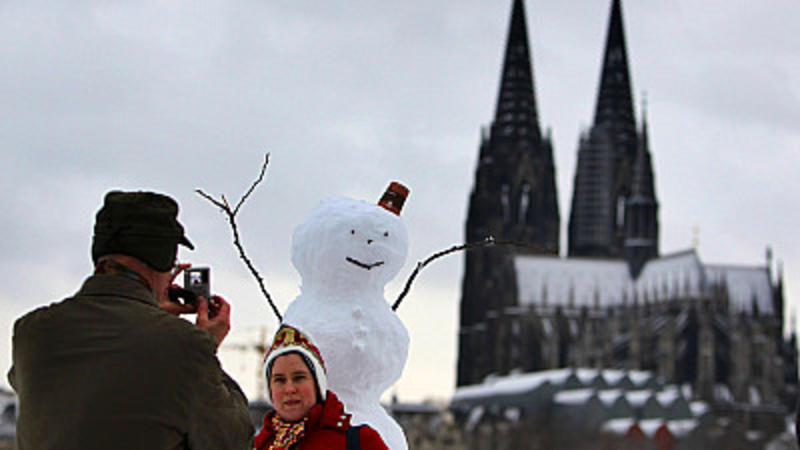 Touristen fotografieren sich am Samstag (09.01.2010) in Köln mit Dom und Schneemann. In Nordrhein-Westfalen ist das befürchtete Schneechaos durch das Sturmtief «Daisy» am Samstag weitgehend ausgeblieben. Zwar verwandelten Verwehungen und Glätte viele