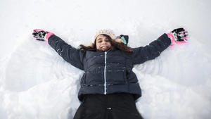 Girl smiling while making snow angel in the snow in front yard United States, Iowa, Grimes PUBLICATIONxINxGERxSUIxAUTxONLY CRLIPF191001-197530-01