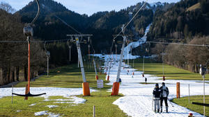 28.12.2022, Bayern, Lenggries: Wintersportler fahren am Draxlhang im Skigebiet Brauneck mit einem Schlepplift die Piste hinauf. Viele Skigebiete in Bayern leiden aktuell unter Schneemangel. Foto: Sven Hoppe/dpa +++ dpa-Bildfunk +++