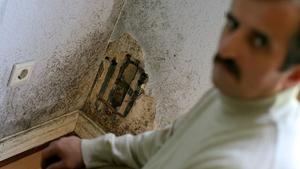 Adem Cirak sitzt am Mittwoch (07.06.2006) in seinem von Schimmel befallenem Schlafzimmer in der Kiefernstraße in Düsseldorf. Lange Zeit war sie die größte Hausbesetzer-Szene Deutschlands: In den 80er Jahren geriet die Düsseldorfer Kiefernstraße durch Großeinsätze der Polizei und als angeblicher Unterschlupf von RAF-Terroristen immer wieder in die Schlagzeilen. Schließlich schloss die Stadt 1988 als Besitzerin der Häuser mit den Bewohnern Mietverträge zu äußerst günstigen Konditionen. Doch nun rumort es wieder in der bunt bemalten Häuserzeile. Schimmelbefall, auslaufende Mietverträge und die Sanierungspläne der Stadt rufen die Mieter auf den Plan. Foto: Felix Heyder dpa/lnw (zu dpa-KORR: "Schimmel in der Kiefernstraße - Ehemalige Hausbesetzerszene verärgert" vom 11.06.2006) +++(c) dpa - Bildfunk+++