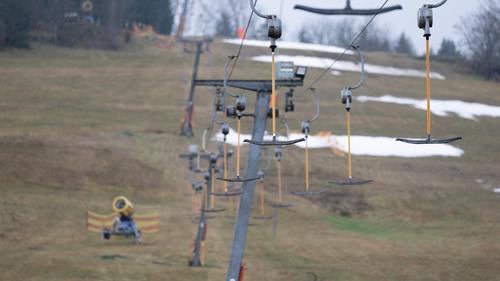13.01.2023, Sachsen, Geising: Leere Bügel hängen an einem Skilift. Nach deutlich über zehn Grad zum Jahreswechsel ist der Schnee in Ostdeutschlands Skigebieten geschmolzen. Foto: Sebastian Kahnert/dpa +++ dpa-Bildfunk +++