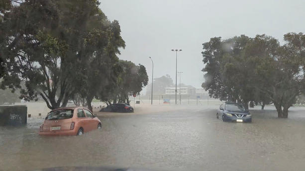 FILE PHOTO: Cars are seen in a flooded street during heavy rainfall in Auckland, New Zealand January 27, 2023, in this screen grab obtained from a social media video. @MonteChristoNZ/via REUTERS//File Photo