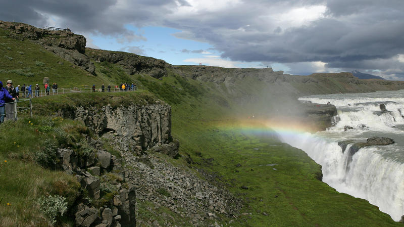 Touristen laufen auf einem Weg über dem Wasserfall Gullfoss (Goldfall) an der Straße F 35 nahe dem Geothermalgebiet Haukadalur in Island, aufgenommen am 12.07.2006. Der Fluss Hvita stürzt an dieser Stelle in zwei Stufen von jeweils über 30 Metern in 