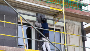 Bauarbeiter isolieren eine Hausfassade