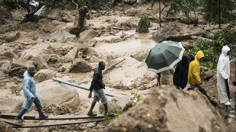 13.03.2023, Malawi, Blantyre: Menschen überqueren einen Fluss in Blantyre. Der außergewöhnlich langlebige Tropensturm «Freddy» hat zum zweiten Mal innerhalb eines Monats im Südosten Afrikas eine Spur der Verwüstung hinterlassen. In Malawi kamen minde
