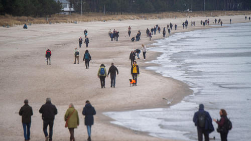 22.03.2023, Mecklenburg-Vorpommern, Binz: Touristen spazieren am Strand des Ostseebades auf der Insel Rügen. Foto: Stefan Sauer/dpa +++ dpa-Bildfunk +++