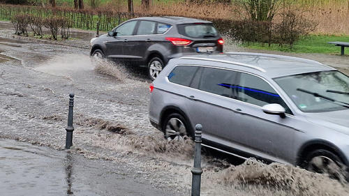 30.03.2023, Brandenburg, Zossen: Autos fahren durch eine von Regen überflutete Straße. Foto: Cevin Dettlaff/dpa-Zentralbild/dpa +++ dpa-Bildfunk +++