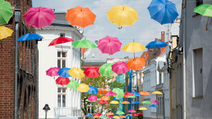 Bunte Regenschirme hängen am 18.05.2016 in einer Gasse in der Altstadt von Lübeck (Schleswig-Holstein). Die Schirme sind Teil der Dekoration für das Hansekultur-Festival, das vom 20. bis zum 22. Mai in der Hansestadt stattfindet. Foto: Daniel Reinhardt/dpa +++(c) dpa - Bildfunk+++