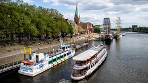 19.05.2023, Bremen: Ein Ausflugsschiff ist bei sonnigem Wetter auf der Weser unterwegs und passiert die Uferpromenade Schlachte und die Altstadt. Foto: Hauke-Christian Dittrich/dpa +++ dpa-Bildfunk +++