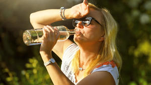 Frau im Garten trinkt Wasser aus einer Flasche, Symbolfoto Hitzewelle || Modellfreigabe vorhanden