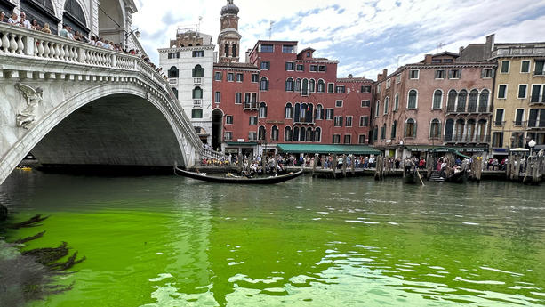 28.05.2023, Italien, Venedig: Gondeln fahren an der Rialto-Brücke auf Venedigs historischem Canal Grande vorbei. Eine grün schimmernde Flüssigkeit im berühmten Canal Grande von Venedig hat für Aufregung in der Lagunenstadt gesorgt. Am Sonntag war das Wasser in der Nähe der Rialto-Brücke plötzlich grün. Die italienische Feuerwehr teilte mit, zusammen mit der Umweltschutzagentur Arpa Proben entnommen zu haben und diese zu untersuchen. Foto: Luigi Costantini/AP/dpa +++ dpa-Bildfunk +++