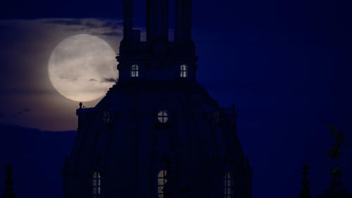 05.05.2023, Sachsen, Dresden: Der Mond geht am Morgen hinter der Frauenkirche unter. Foto: Robert Michael/dpa +++ dpa-Bildfunk +++
