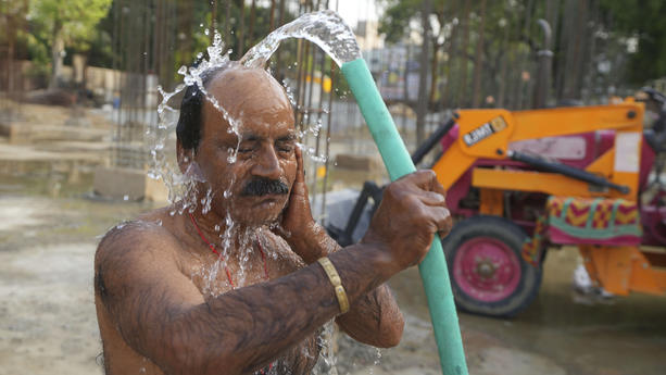22.05.2023, Indien, Prayagraj: Ein Arbeiter erfrischt sich mit Wasser aus einem Schlauch an einer Baustelle in Prayagraj im nördlichen Bundesstaat Uttar Pradesh von Indien. Die Hitzewelle in dem Bundesstaat wird wahrscheinlich noch zwei weitere Tage anhalten, sagte ein Beamter des indischen Wetterdienstes. Foto: Rajesh Kumar Singh/AP +++ dpa-Bildfunk +++