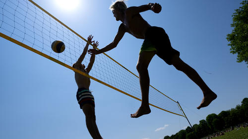 03.06.2023, Bayern, München: Zwei Männer spielen bei sommerlichen Temperaturen im englischen Garten Beachvolleyball. Laut Deutscher Wetterdienst bleibt das Wetter in den nächsten Tagen weiterhin freundlich. Foto: Sven Hoppe/dpa +++ dpa-Bildfunk +++