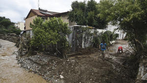 Locals clean the area next to a stream following heavy rainfall in Thessaloniki, northern Greece, Saturday, June 17, 2023. Houses were flooded and trees fell as cars were swept away after intense rainfall at many suburbs of the northern city. (AP Photo/Giannis Papanikos)