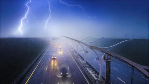 Cars driving on a highway in a pouring rain with a thunderstorm. Storm, lightning and fog over dark road