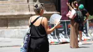 16.07.2023, Italien, Palermo: Eine Frau benutzt ihren Fächer während der Hitze. Temperaturen um die 40 Grad tagsüber und 30 Grad nachts machen den Menschen in weiten Teilen Südeuropas zu schaffen. Foto: Alberto Lo Bianco/LaPresse via ZUMA Press/dpa +++ dpa-Bildfunk +++