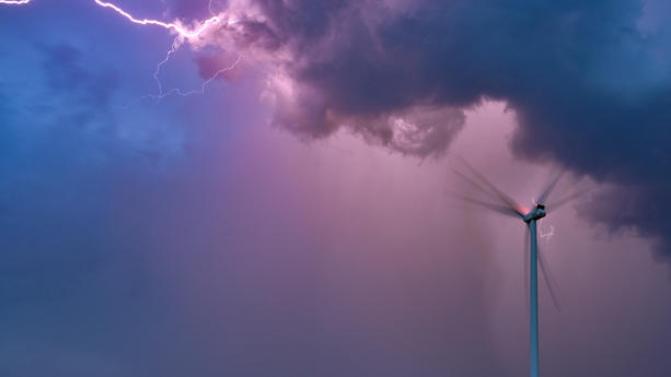 15.08.2023, Brandenburg, Petersdorf: Ein Blitz eines Gewitters leuchtet am Abendhimmel über einer Windenergieanlage im Osten des Landes Brandenburg. Schwere Gewitter sind am Dienstag über viele Regionen in Deutschland hinweg gezogen. Foto: Patrick Pleul/dpa +++ dpa-Bildfunk +++