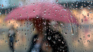 Regenwasser läuft am Mittwoch (05.10.2011) in Fulda an einer Glasscheibe herunter, an der gerade eine Frau mit Regenschirm vorbeigeht. Mit kühleren Temperaturen und Regen hat sich der Herbst endgültig vorstellig gemacht. Die warmen Spätsommertage sind vorüber. Foto: Uwe Zucchi dpa/lhe  +++(c) dpa - Bildfunk+++