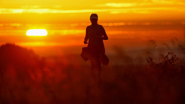 17.09.2023, Baden-Württemberg, Unlingen: Eine Frau joggt am Morgen auf einem Weg, während im die Sonne auf geht. Foto: Thomas Warnack/dpa +++ dpa-Bildfunk +++