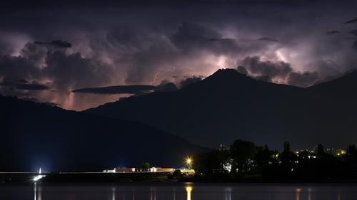 13.08.2023, Frankreich, Savines-Le-Lac: Blick von den französischen Westalpen über den Lac de Serre-Poncon hinweg auf ein schweres Gewitter in der Gegend von Turin (Italien). Das Unwetter richtete in der Nacht zum 14. August 2023 schwere Schäden westlich von Turin an. Ein Erdrutsch und eine Schlammlawine infolge schwerer Regenfälle haben in der norditalienischen Gemeinde Bardonecchia große Schäden angerichtet. Foto: Jan Woitas/dpa +++ dpa-Bildfunk +++