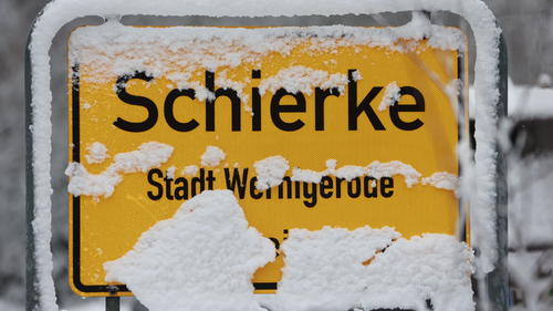 24.11.2023, Sachsen-Anhalt, Schierke: Mit Schnee bedeckt ist das Ortseingangsschild von Schierke. Am frühen Morgen setzten erste Schneefälle in den Harzbergen ein. Der Harzgipfel und einige Bergregionen des Harzes liegen unter einer weißen Schneedecke. Das winterliche Wetter setzt sich in den kommenden Tagen fort. Foto: Matthias Bein/dpa +++ dpa-Bildfunk +++