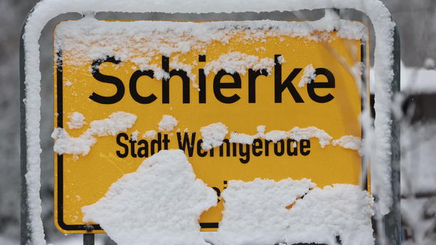 24.11.2023, Sachsen-Anhalt, Schierke: Mit Schnee bedeckt ist das Ortseingangsschild von Schierke. Am frühen Morgen setzten erste Schneefälle in den Harzbergen ein. Der Harzgipfel und einige Bergregionen des Harzes liegen unter einer weißen Schneedecke. Das winterliche Wetter setzt sich in den kommenden Tagen fort. Foto: Matthias Bein/dpa +++ dpa-Bildfunk +++