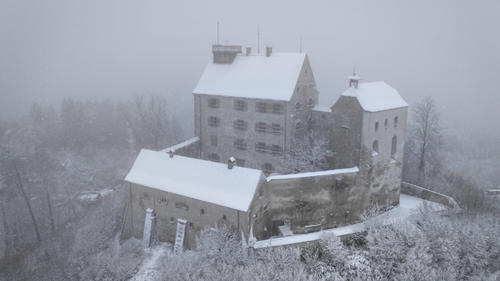 26.11.2023, Baden-Württemberg, Waldburg: Die Burg Waldburg ist mit Schnee bedeckt (Aufnahme mit Drohne). Über Nacht hat es in Oberschwaben und dem Allgäu zu schneien begonnen. Foto: Felix Kästle/dpa +++ dpa-Bildfunk +++