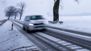 06.12.2023, Mecklenburg-Vorpommern, Groß Strömkendorf: Ein Auto fährt über eine verschneite Straße. (Aufnahme mit langer Belichtungszeit) Anhaltender Schneefall und Temperaturen unter dem Gefrierpunkt behindern den Verkehr in Norddeutschland. Foto: Jens Büttner/dpa +++ dpa-Bildfunk +++